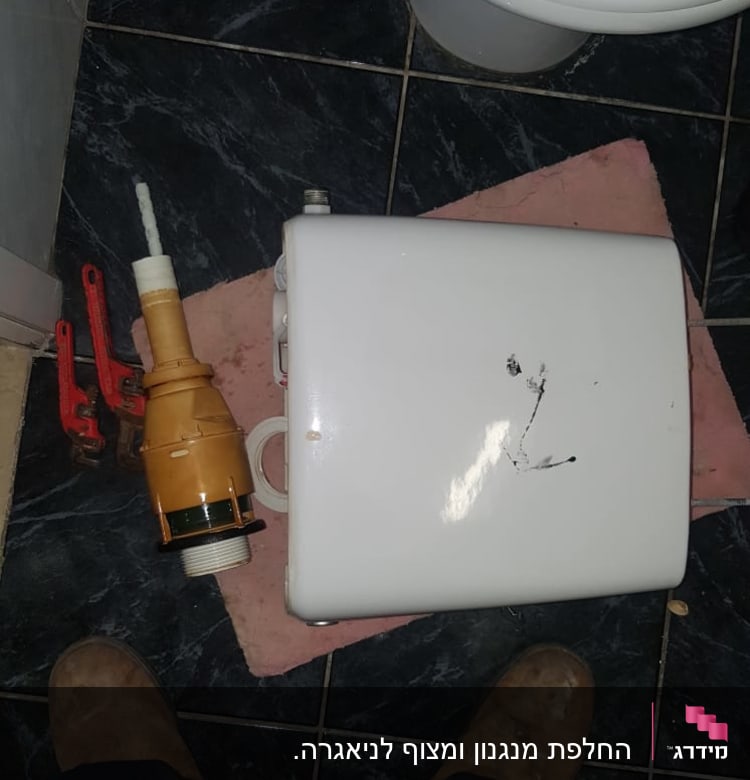 מיכל הדחה, כלי עבודה וצנרת על רצפה
